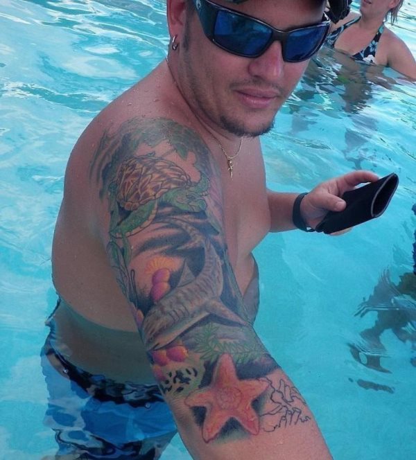 Este chico lleva un colorido tatuaje en la parte superior de su brazo Este chico lleva un colorido tatuaje en la parte superior de su brazo