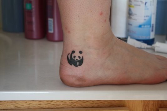 Divertido oso panda tatuado en el pie, muy cerca del tobillo Divertido oso panda tatuado en el pie, muy cerca del tobillo